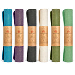 CompleteGrip™ Jute Non-Slip Yoga Mat photograph of rolled yoga mats in Forest Green, Space Black, Eco Natural White, and Majestic Purple Matcha Green