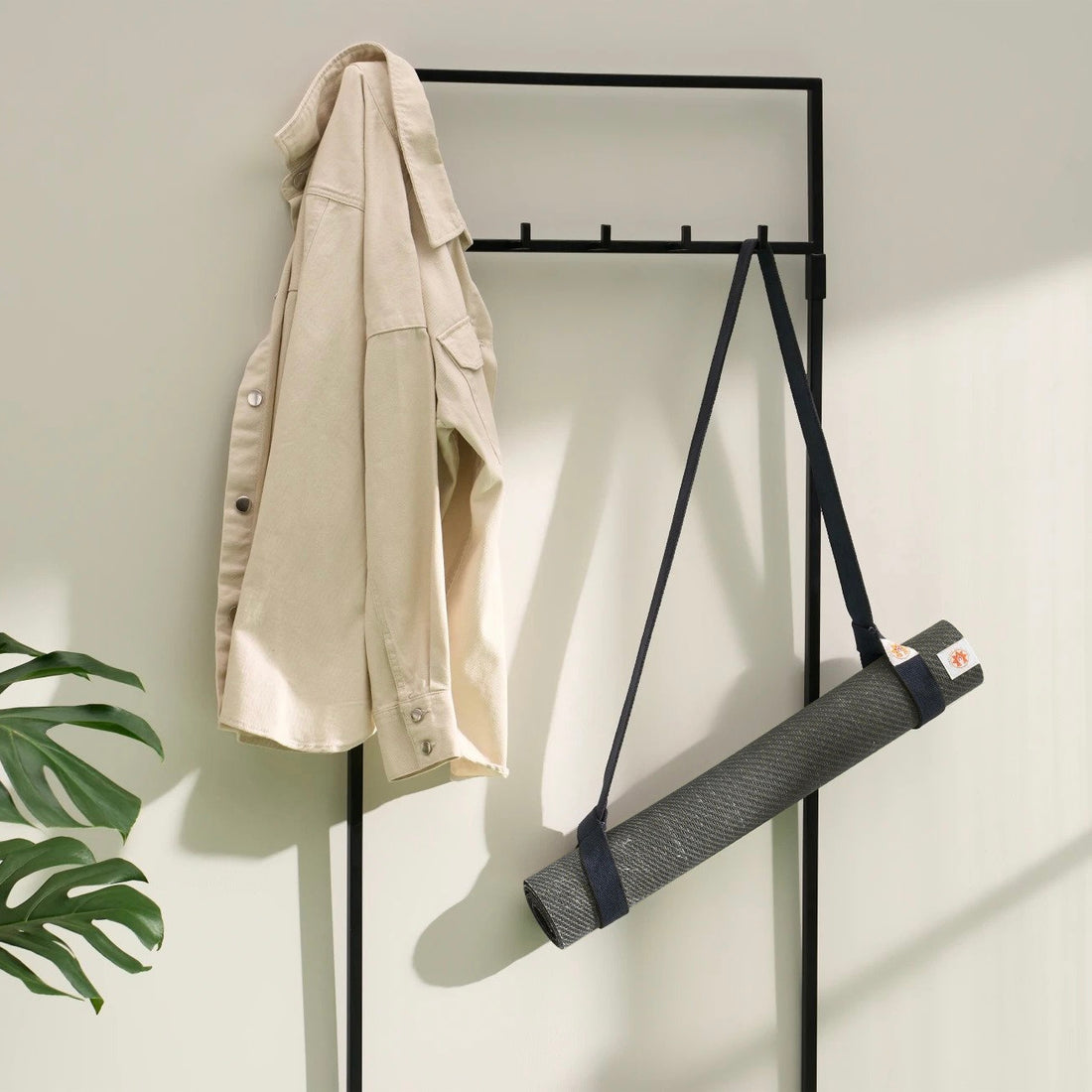 Lifestyle photo of jute yoga mat and yoga mat carrying strap ready to go in stylish modern home Space Black #4mm-yoga-mat-colour_space-black